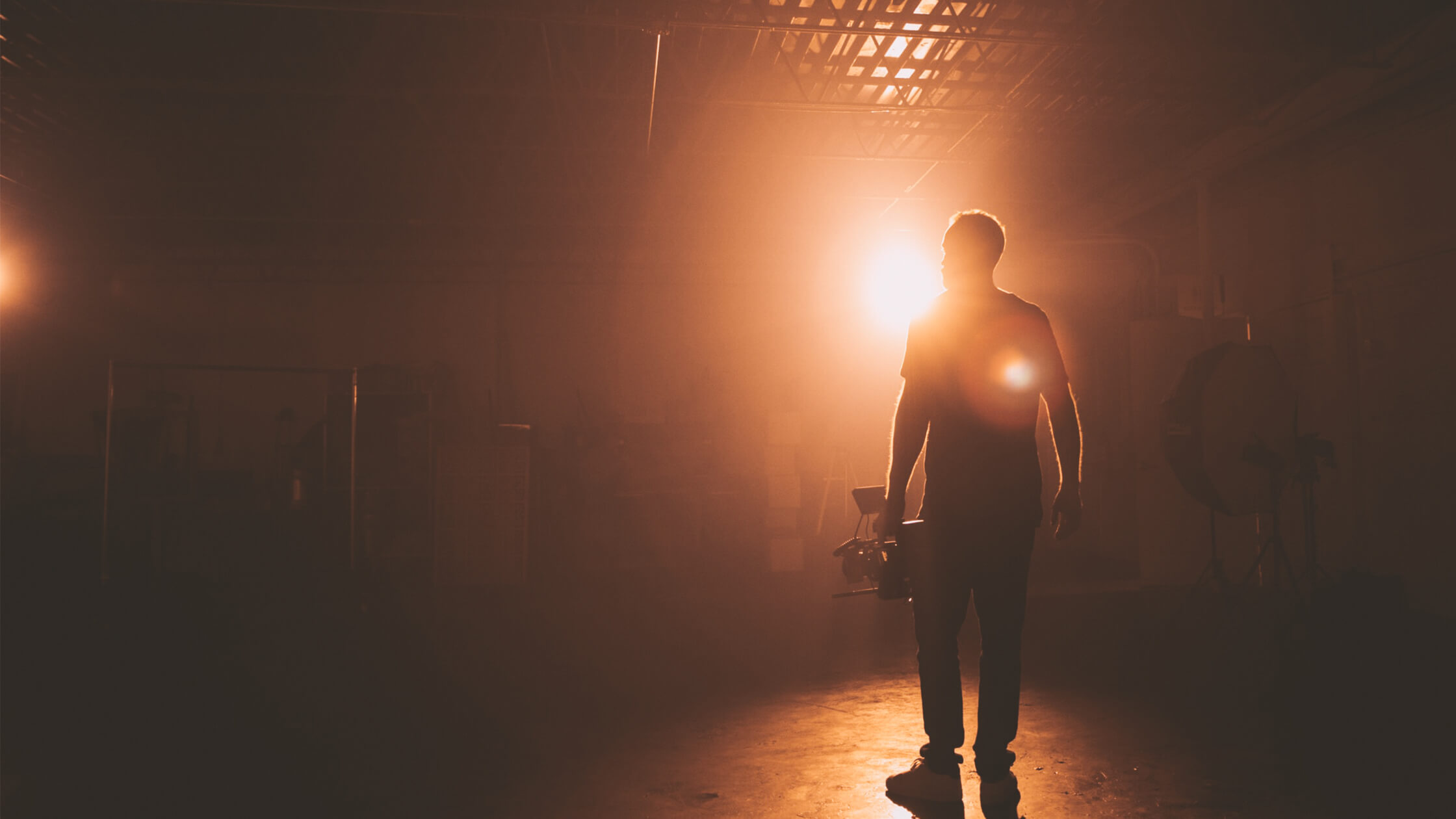 Cinematographer holding camera on a dark set