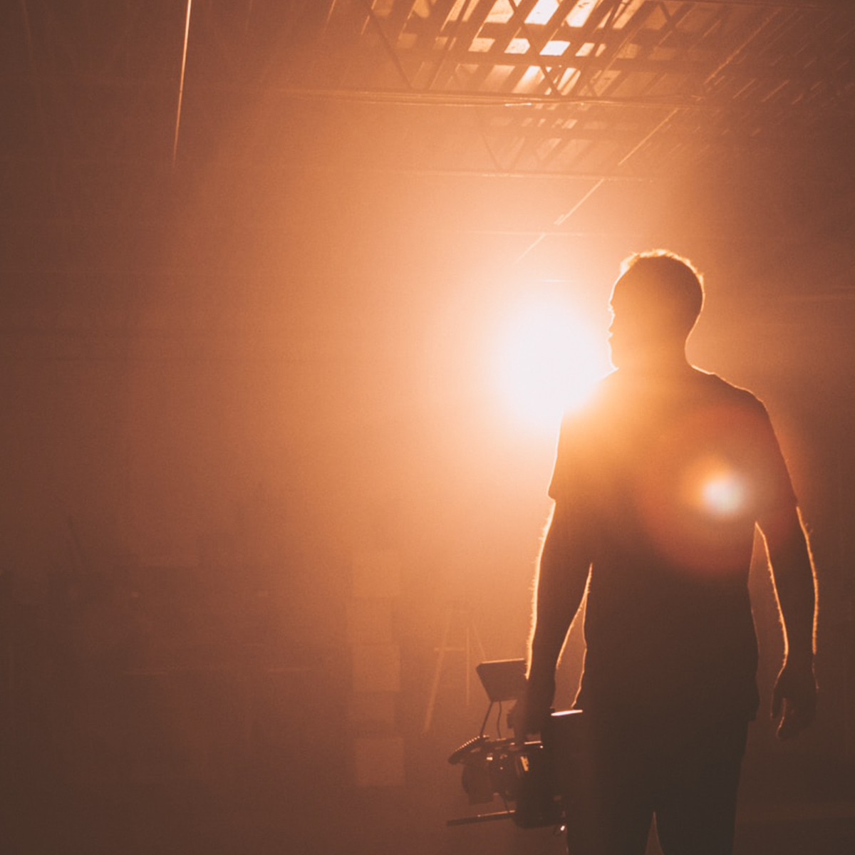 Cinematographer holding camera on a dark set